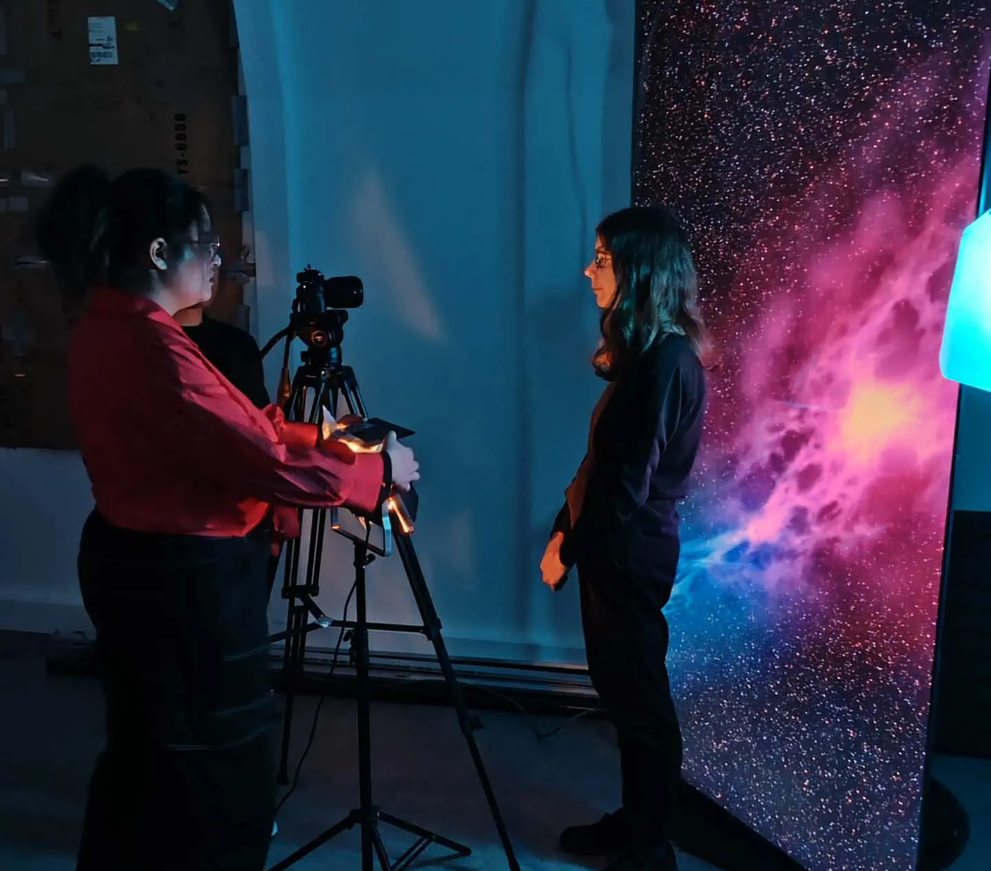 Étudiantes réalisant un projet audiovisuel avec caméra et éclairage créatif.